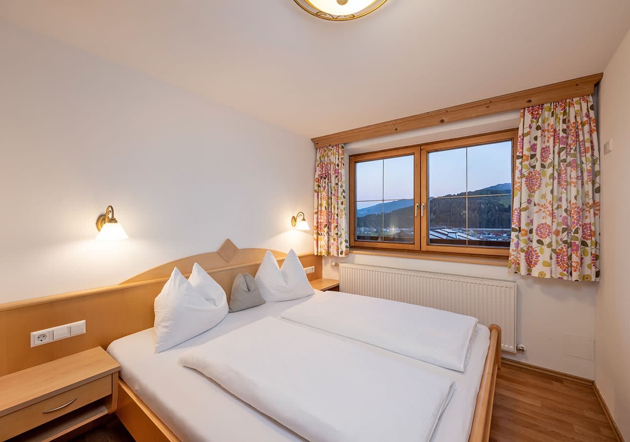 Cozy bedroom with a double bed and a window overlooking a scenic view