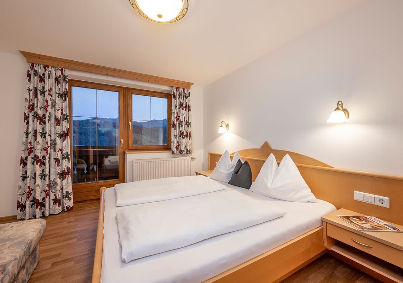 Cozy hotel room with a double bed and mountain views through the window