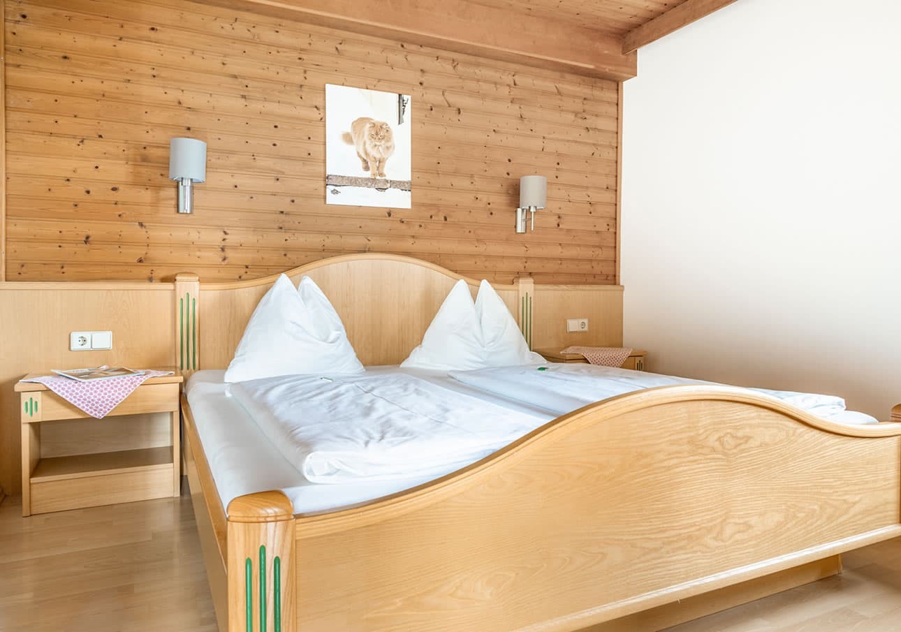 A cozy wooden bedroom with a double bed and wall art above