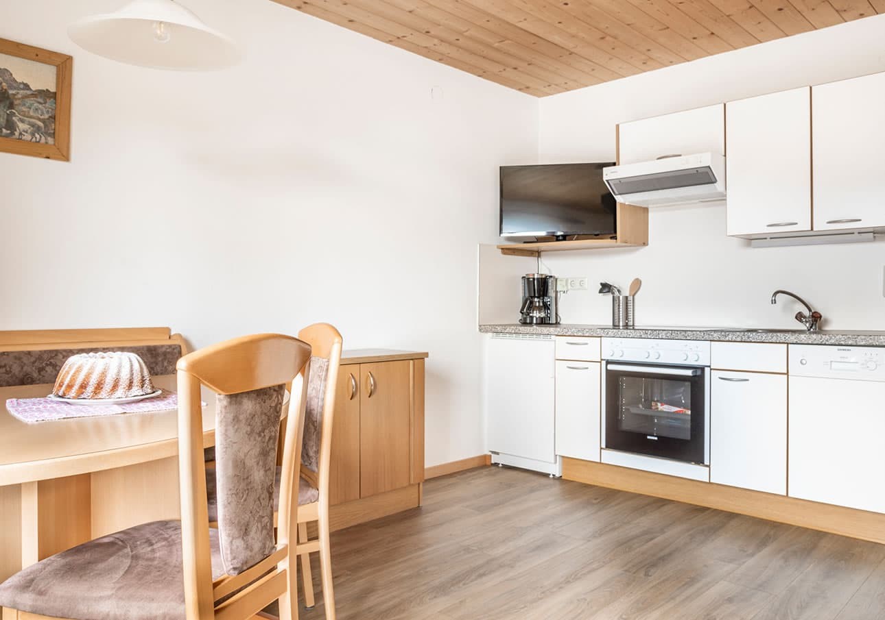 Cozy kitchen with wooden furniture and modern appliances, including a stove and coffee maker