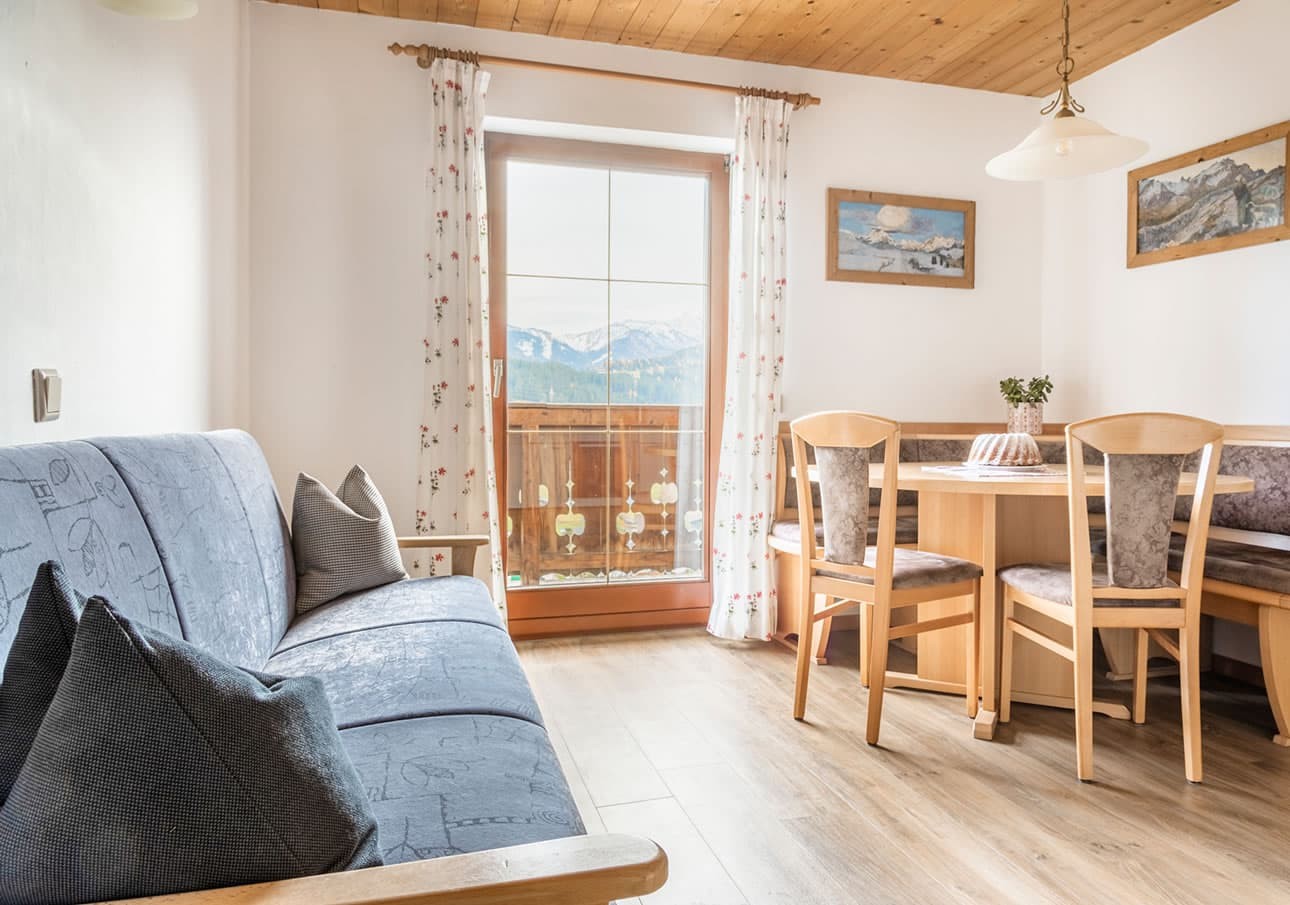 Cozy room with wooden furniture, sofa, and mountain view through a window