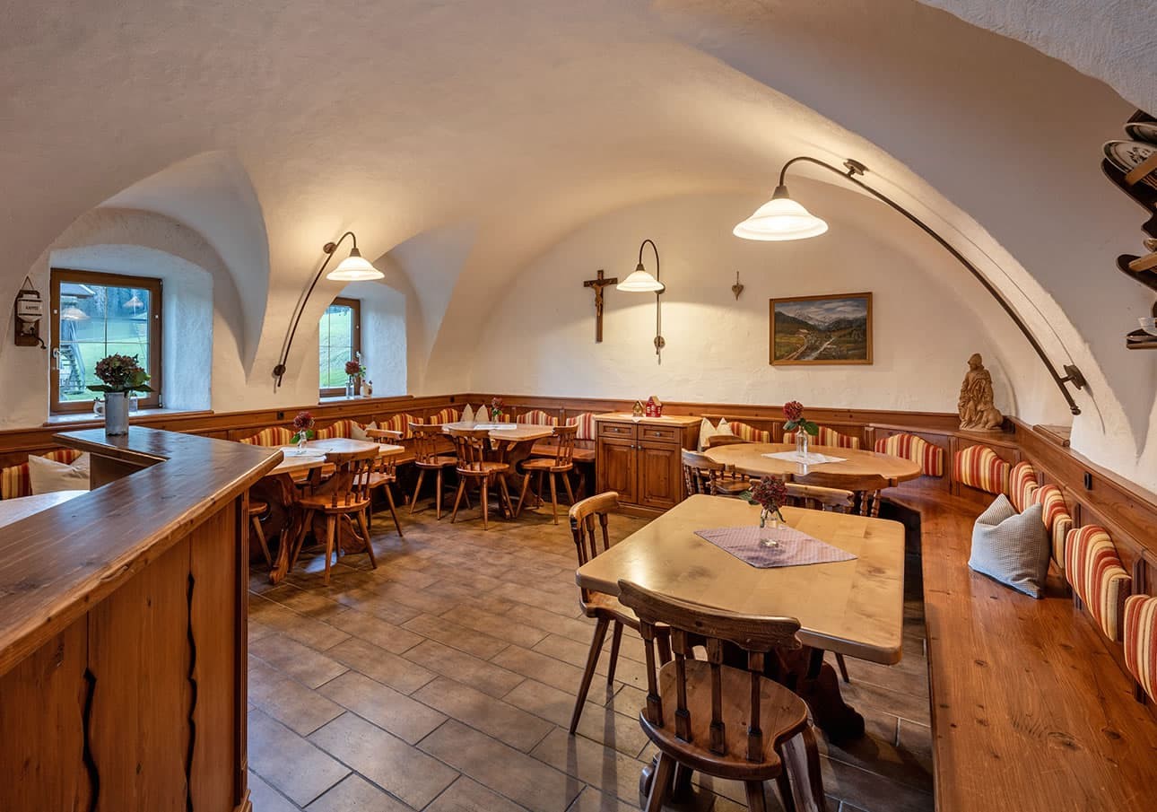 Cozy Bauernstube with wooden tables, benches, and decorative pictures on white walls