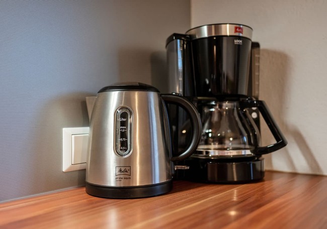 Wasserkocher und Kaffeemaschine auf einer Holzarbeitsplatte in einer Küche