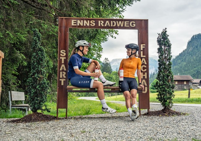 Zwei Radfahrer pausieren am Startpunkt des Enns Radwegs in Flachau