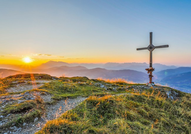 Berggipfel Grießenkar bei Sonnenuntergang mit einem Gipfelkreuz und Blick auf die Berge