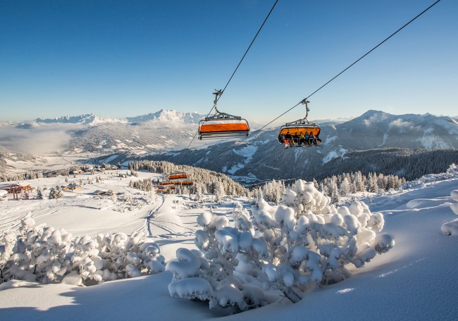 Seilbahn über schneebedeckter Landschaft mit Bergen im Hintergrund