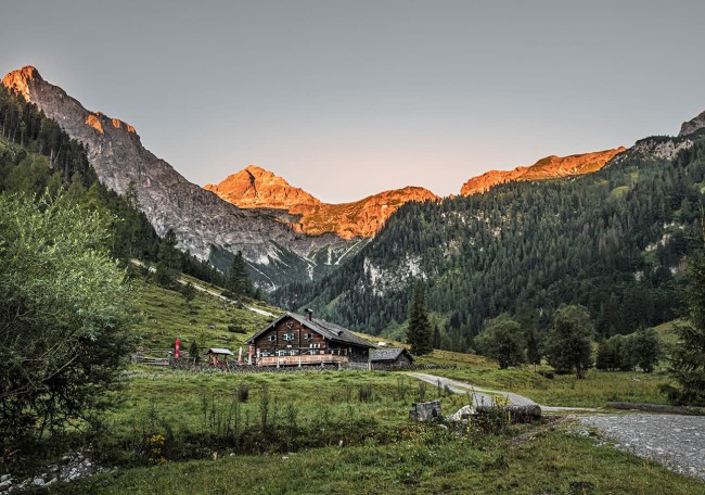 Prechtlalm in einer grünen Berglandschaft bei Sonnenuntergang
