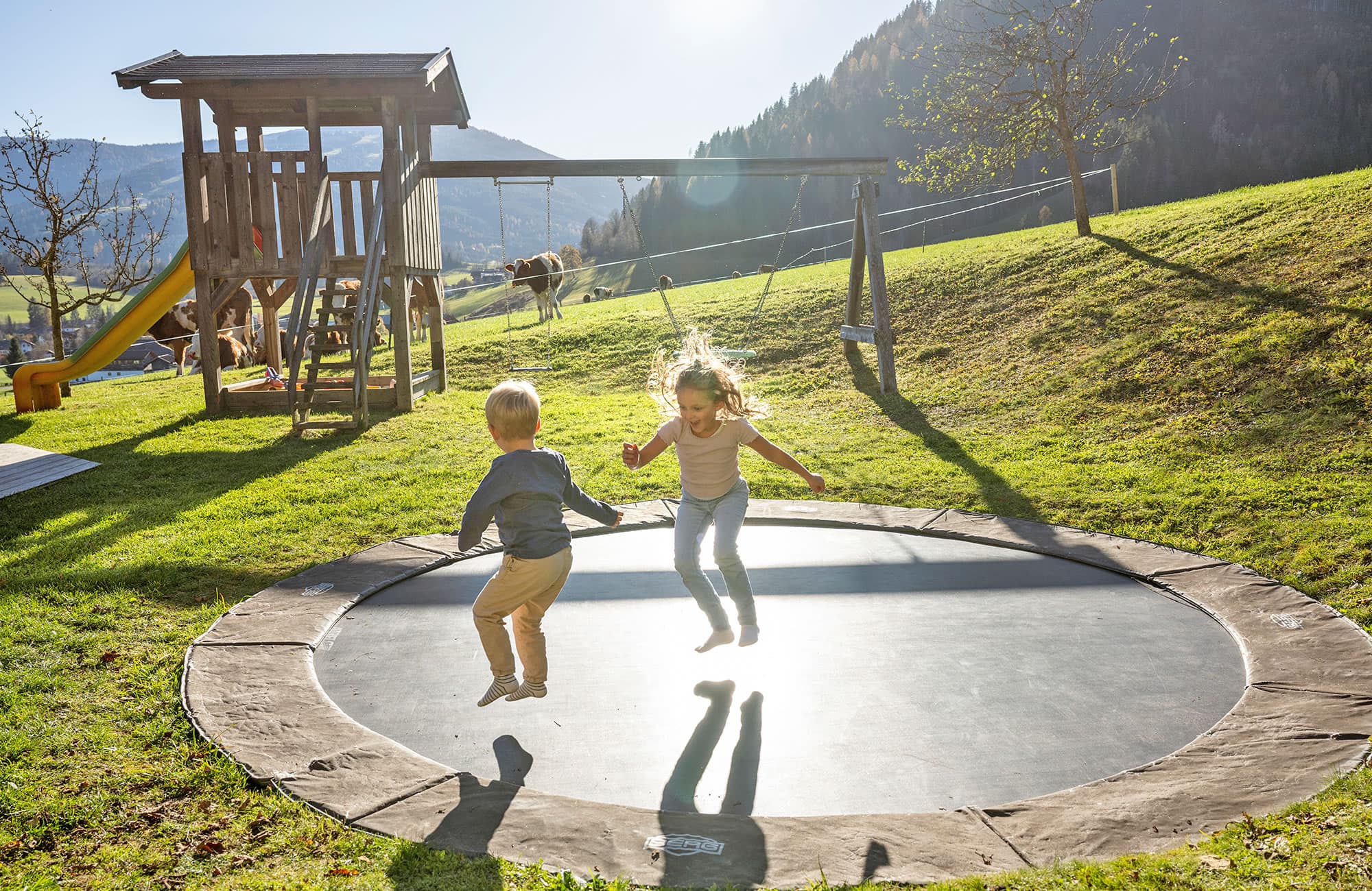 Trampolin springen im großen Garten mit Spielplatz und viele Wiese zum Herumtollen