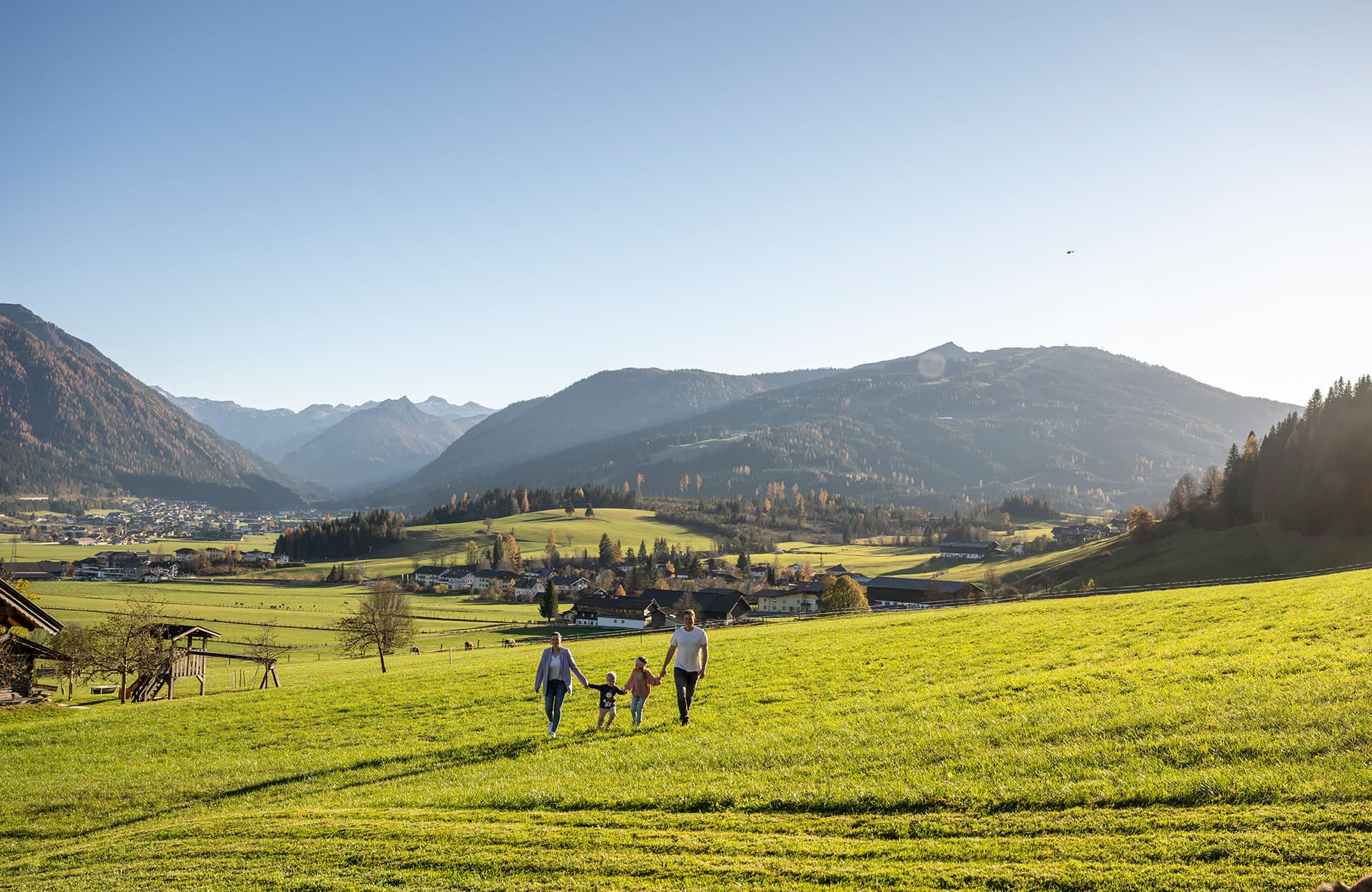 Family walking on the meadow during a farm holiday at Prechtlhof in Flachau