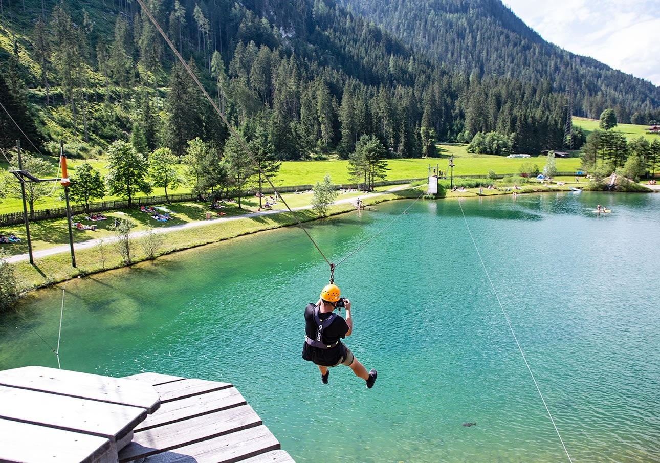 On the flying fox over the bathing lake Flachauwinkl in the high rope garden
